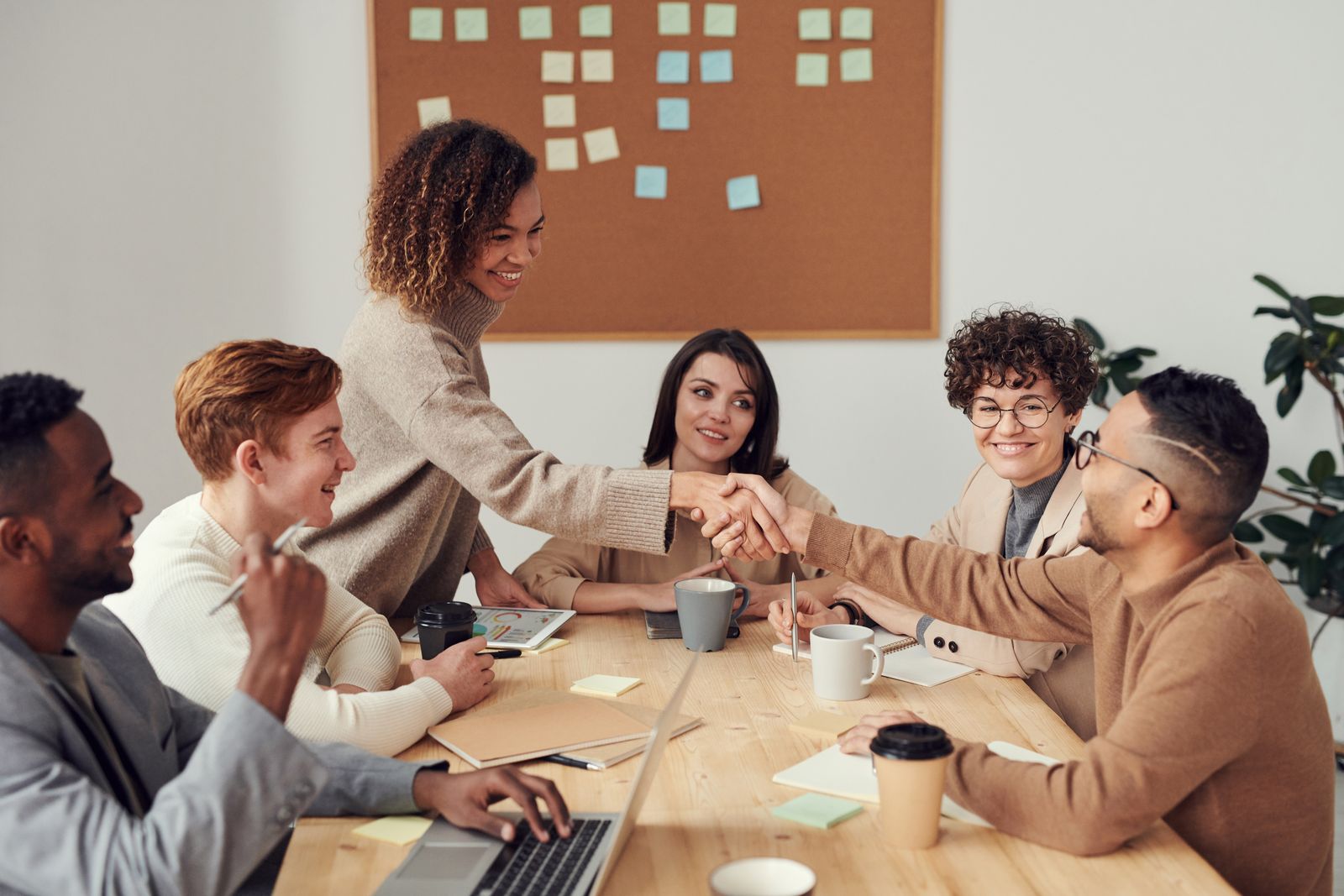A team meeting where two colleagues shake hands