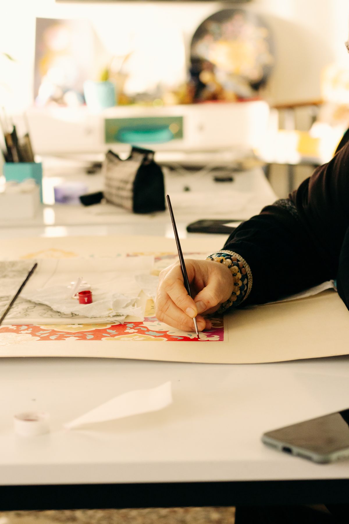An artist creating work in a bright studio